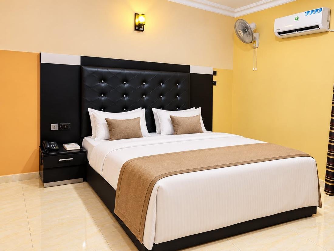 Royal Room bed with tufted headboard and beige runner